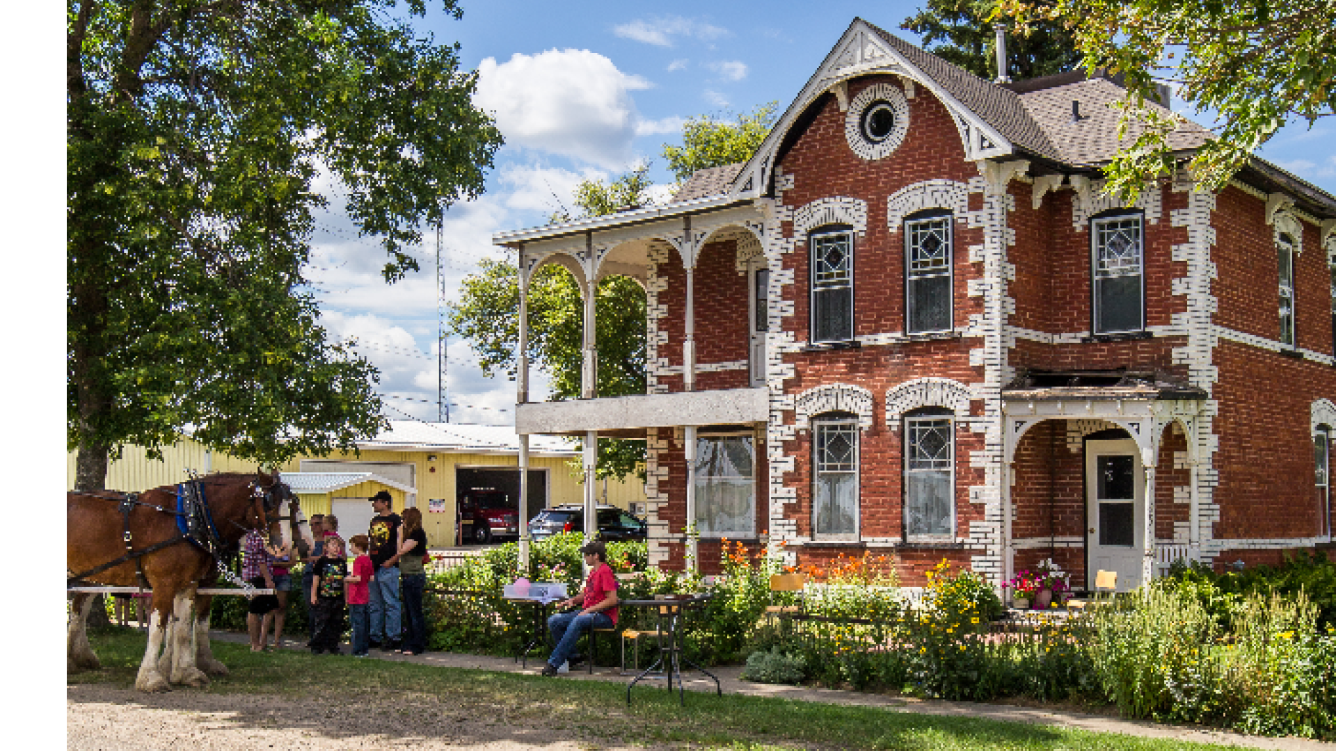 A historical red bricked building with visitors.
